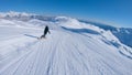 FOLLOW: Unrecognizable active female tourist snowboarding down an empty slope.