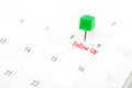 Follow Up written on  a calendar with a green push pin to remind you and important appointment Royalty Free Stock Photo