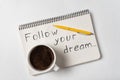 Follow your dream notice. Notepad, pen and cup of coffee on white background Royalty Free Stock Photo
