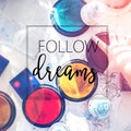 Follow your dreams quote concept with a boy having fun while playing with stamps and tempera paints as do what you love theme Royalty Free Stock Photo