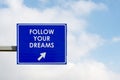 Follow Your Dreams words displayed on blue road sign Royalty Free Stock Photo