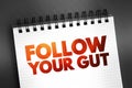 Follow Your Gut text on notepad, concept background Royalty Free Stock Photo