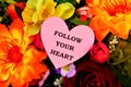Follow your heart- an inscription on the background of summer garden flowers . Listening only to what it tells you is a sure way