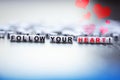 Follow your heart text spelled with plastic letter beads Royalty Free Stock Photo
