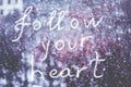 Follow your heart, written by hand on the snowstorm winter background, toned Royalty Free Stock Photo