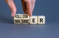 Follower or influencer symbol. Concept words Follower Influencer on wooden cubes. Beautiful grey table grey background.