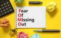 FOMO fear of missing out symbol. Concept words FOMO fear of missing out on white note on a beautiful yellow background. Black Royalty Free Stock Photo