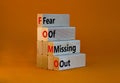 FOMO fear of missing out symbol. Concept words FOMO fear of missing out on wooden blocks on a beautiful orange background. Copy Royalty Free Stock Photo