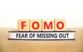 FOMO fear of missing out symbol. Concept words FOMO fear of missing out on wooden cubes on book on a beautiful white background. Royalty Free Stock Photo