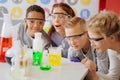 Overjoyed teenage students observing final stage of chemical experiment