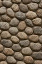 Roughly oval-shaped stones are arranged in a tightly packed pattern, forming a natural stone wall. Royalty Free Stock Photo