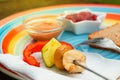 Fondue with assorted cubed fresh meat and vegetable on colored plate Royalty Free Stock Photo