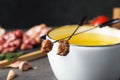 Fondue pot and forks with cooked meat on table. Space for text Royalty Free Stock Photo