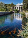 Fontaine de Vaucluse, Provence, France. The old bridge over the river reflected in water.