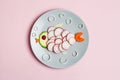 Creative children breakfast, cute funny fish made of colorful fresh tasty vegetables, carrot, zucchini, tomato, radish isolated on