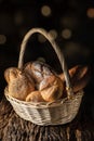 A basket with assortment of bread on wooden plank with dark background Royalty Free Stock Photo
