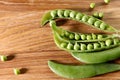 Food background. Close-up of opened green pea pods on a wooden table. Royalty Free Stock Photo