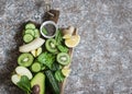 Food background. Detox green vegetables and fruits on a wooden board. Concept of a healthy, diet food.