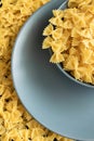 Food background - dry farfalle pasta on grey plate, whole wheat uncooked ingredient Royalty Free Stock Photo