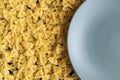 Food background - dry farfalle pasta on grey plate, whole wheat uncooked ingredient