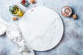 Food background with free space for text. Olive oil, spices around white marble board on light gray stone table.