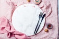 Food background with free space for text. Spices around white marble board on pink tablecloth.