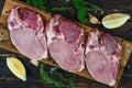 Food background of fresh raw meat of pork chop cutlet steak on wooden board with lemon, green pepper, thyme andv black pepper Royalty Free Stock Photo