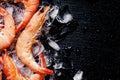 Food background, frozen cooked shrimp with ice, black background