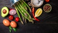 Food background with green asparagus and various ingredients and jars with preserved vegetables, seasoning. tasty home cooking. Royalty Free Stock Photo