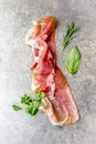 Food background with ham jamon serrano and herbs - rosemary, basil and watercress salad, stone gray background, top view Royalty Free Stock Photo