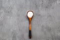 Food background with spoon of salt. Flat lay overhead top view of wooden spoon with salt on gray concrete background Royalty Free Stock Photo