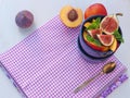 Food background. Summer fruits upon purple napkin and in a bowl with fresh mint leaves. Healthy eating concept. Royalty Free Stock Photo