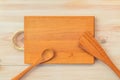 Food background. Top view of empty wooden cutting board, spoon and spatula on planks vintage table with copy space Royalty Free Stock Photo