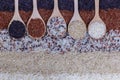 Food background with top view of five rows of rice in a wooden spoon