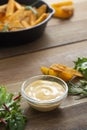 Food background. Top view of sauce and roasted potato in a frying skillet pan on wooden table. Copy space