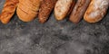 Food baking banner. Various types of fresh homemade bread on a gray concrete background. Top view. Horizontal shot. Copy space