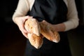 close up of female baker holding baguette bread Royalty Free Stock Photo