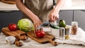 Food banner. A young chef in a brown apron uses a kitchen knife to cut vegetables for a delicious vegetarian salad. Cooking Royalty Free Stock Photo