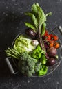 Food basket with fresh garden vegetables - beets, broccoli, eggplant, asparagus, peppers, tomatoes, cabbage on a dark table Royalty Free Stock Photo