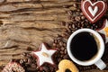 Food and beverage background of a cup of hot black coffee and assortment of cookies and roasted coffee beans on wooden plank