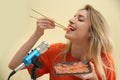 Food blogger eating in front of microphone against light background. Mukbang Royalty Free Stock Photo