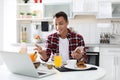 Food blogger with laptop and phone in kitchen. Royalty Free Stock Photo