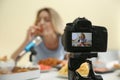 Food blogger recording eating show against light background, focus on camera screen. Mukbang vlog Royalty Free Stock Photo