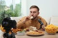 Food blogger recording eating show on camera in room. Mukbang vlog Royalty Free Stock Photo