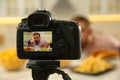 Food blogger recording eating show in kitchen, focus on camera screen. Mukbang vlog