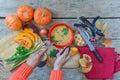 Pumpkin soup on wooden background, vintage. Woman hands, cooking process.