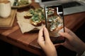 Food blogger taking photo of her lunch at cafe, closeup Royalty Free Stock Photo