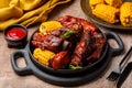 Food board with baked pork ribs with corn cobs, barbecue sauce, rosemary.