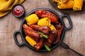 Food board with baked pork ribs with corn cobs, barbecue sauce, rosemary.