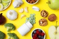 Food and bottle of prebiotic pills on yellow background, flat lay Royalty Free Stock Photo